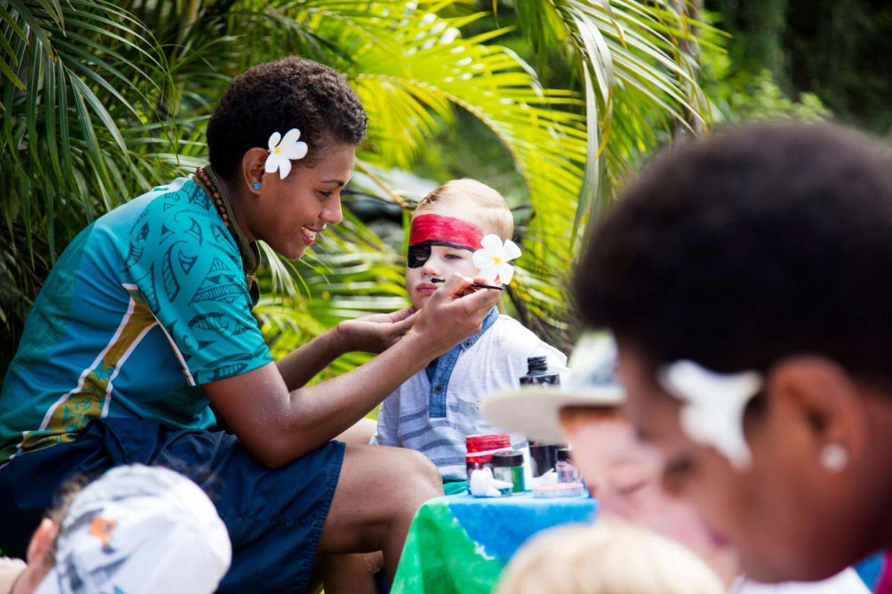Outrigger Fiji Beach Resort Korotogo Esterno foto A young woman from the Cook Islands applying titi muka to a child's face